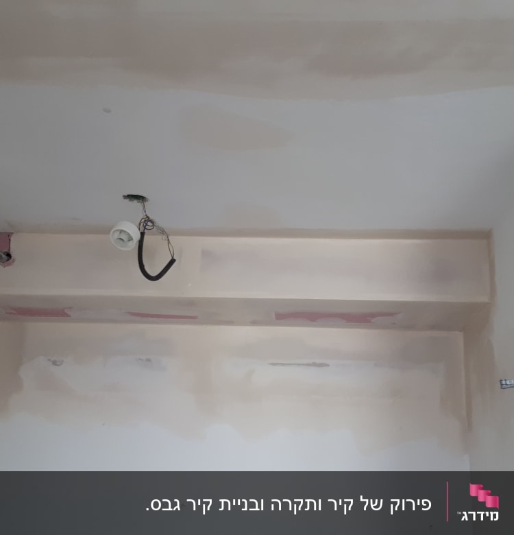 קיר גבס עם צינור אדום ותקרה חלקית